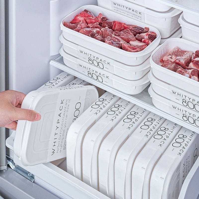 A hand reaches for a white plastic container inside a neatly organized refrigerator.