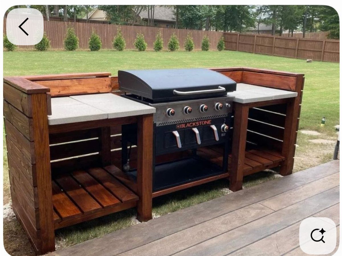 A Blackstone griddle integrated into a custom wooden outdoor kitchen station on a deck.