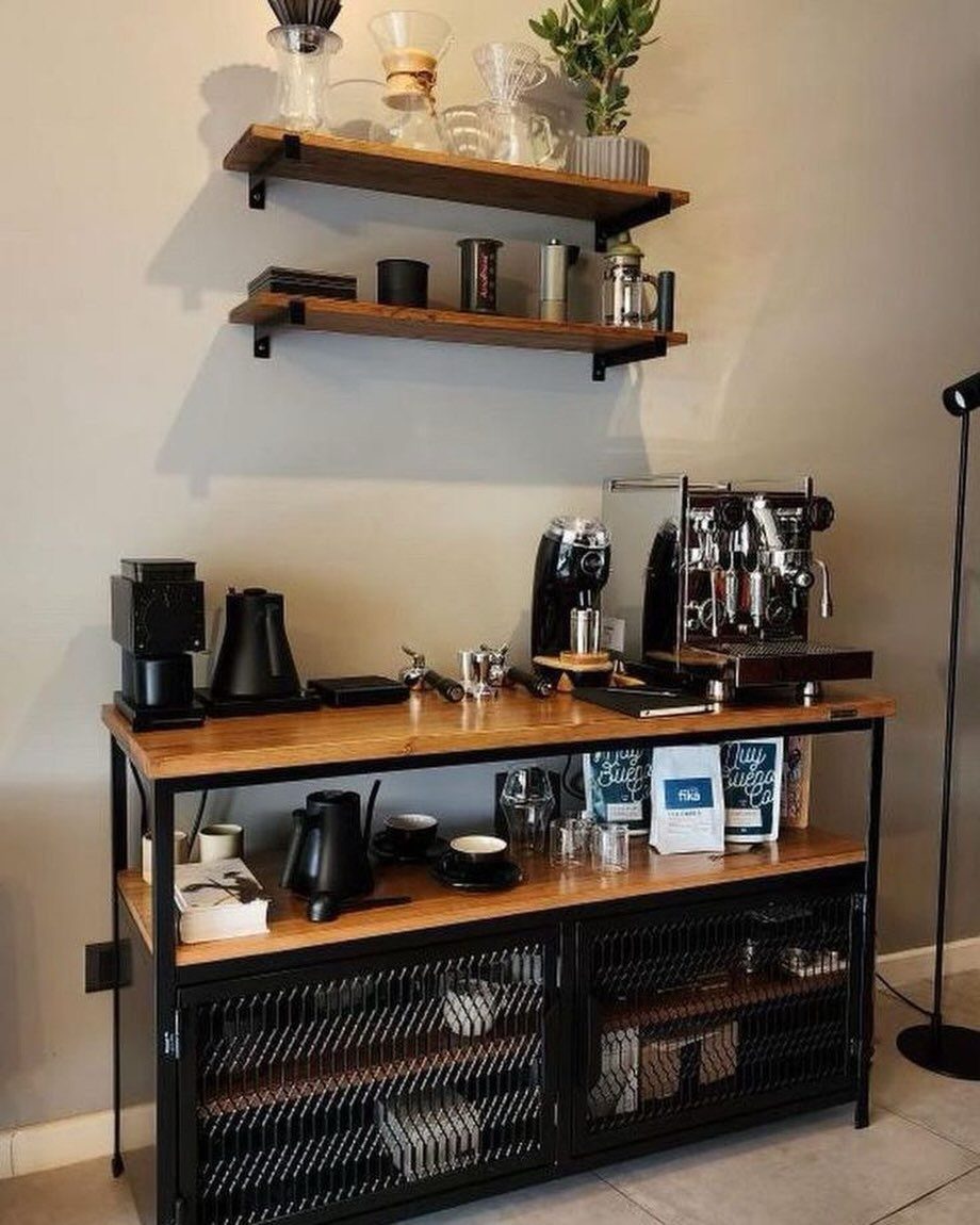 A wooden and black metal coffee station with espresso machines and brewing equipment on shelves.