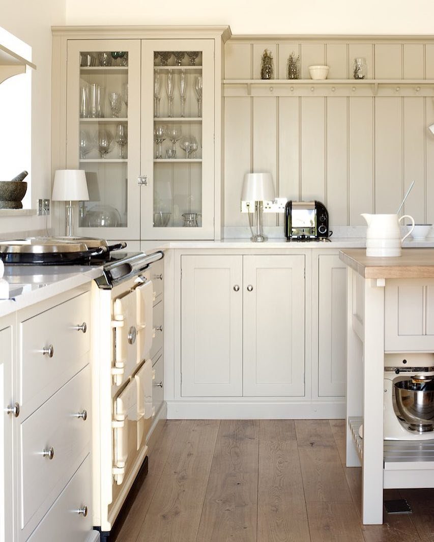 Cream Shaker-style kitchen cabinets with glass display doors and a vintage cream range cooker.