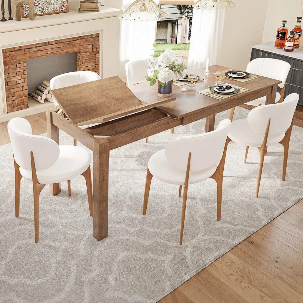A wooden dining table being extended with white chairs on a grey patterned rug.