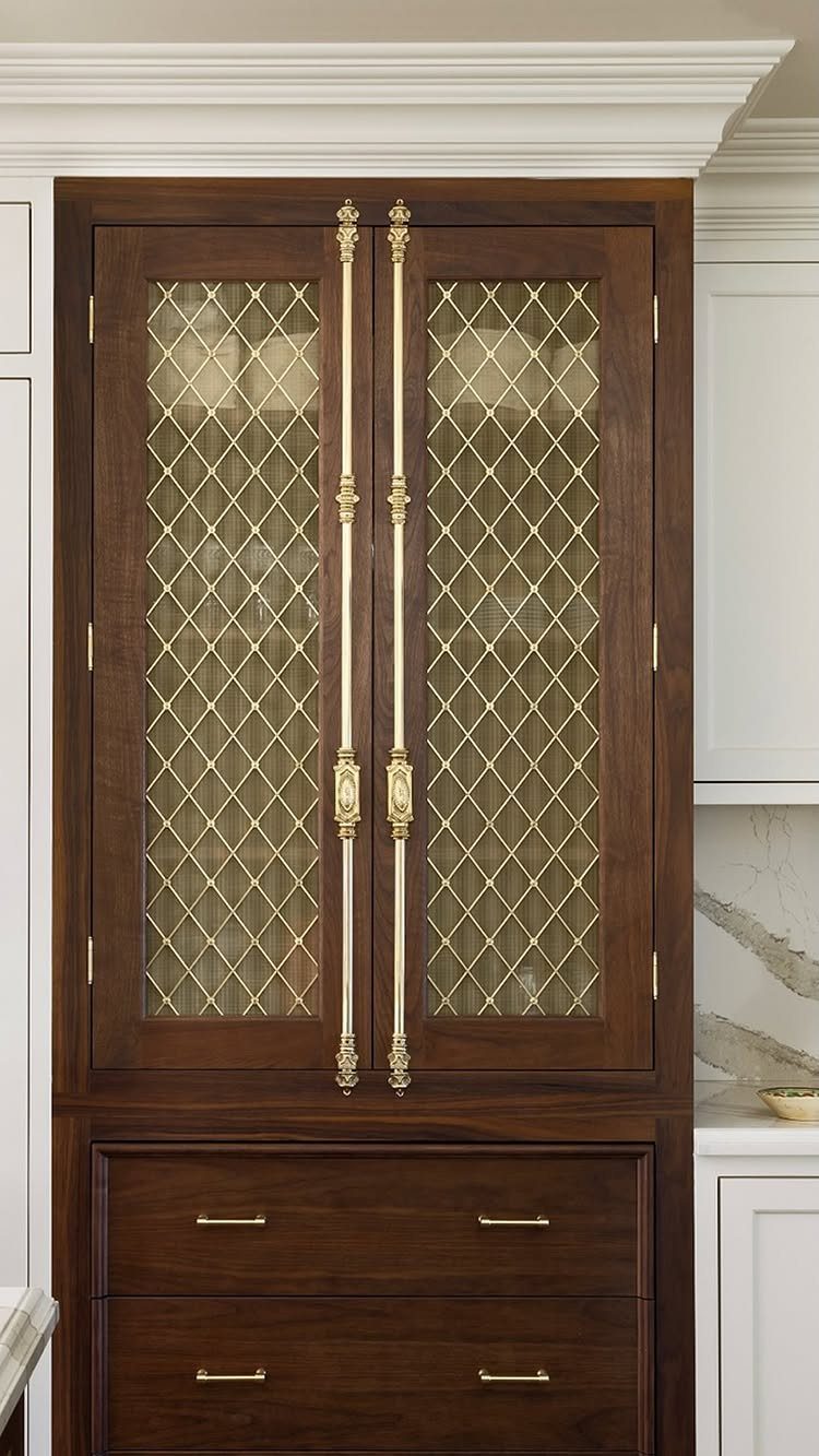 Dark wood cabinet with ornate brass handles and gold lattice glass doors.