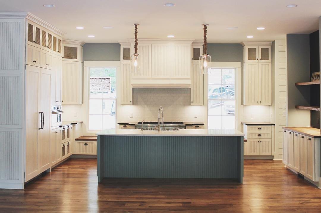 Blue kitchen island with beadboard paneling in a bright, modern farmhouse kitchen setting.