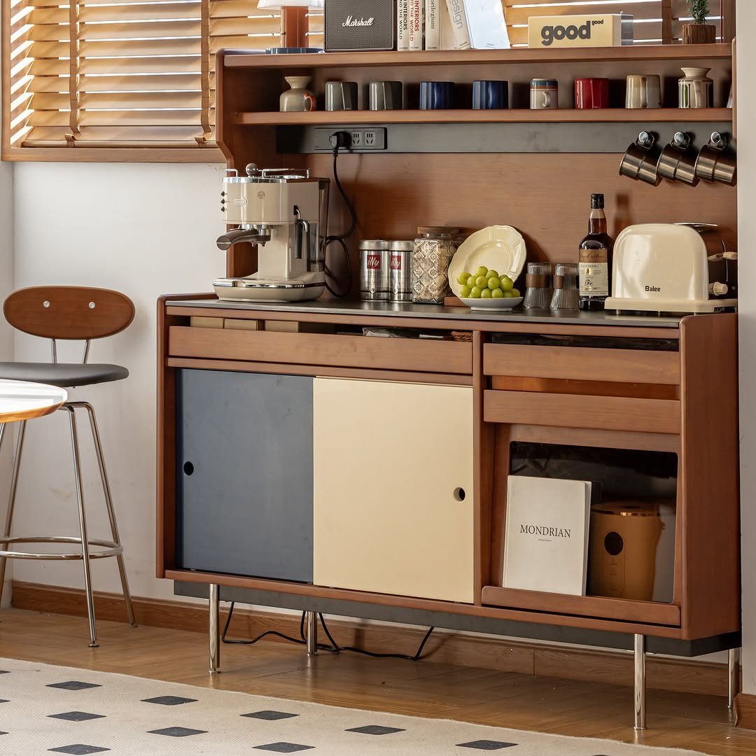 A wooden mid-century modern hutch holding an espresso machine, toaster, and various kitchen accessories.