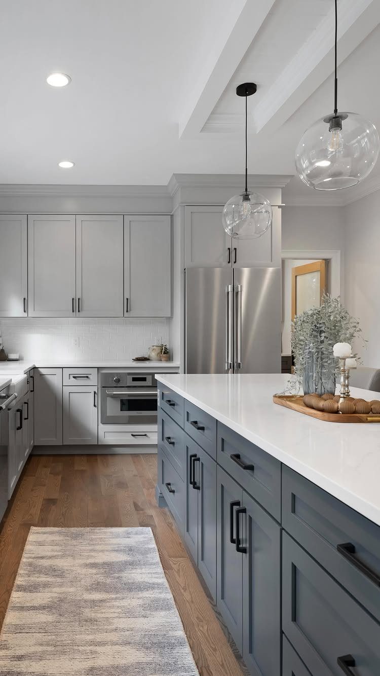 Modern kitchen with light gray cabinetry, white marble backsplash, and a large blue island.
