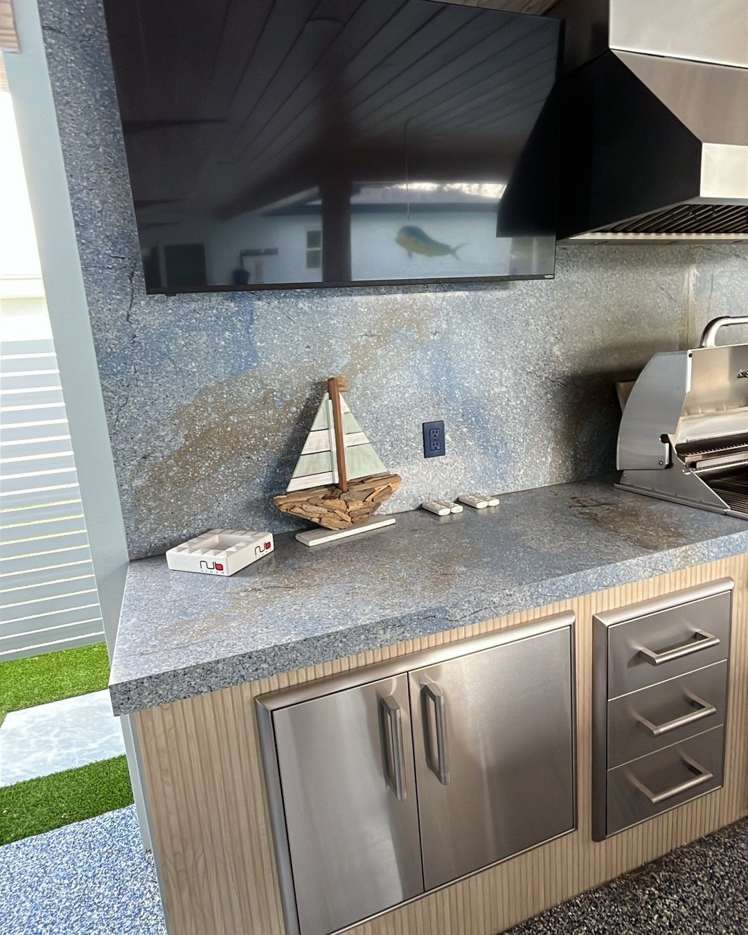 Stainless steel cabinets and drawers integrated into a modern outdoor kitchen island with granite countertops.