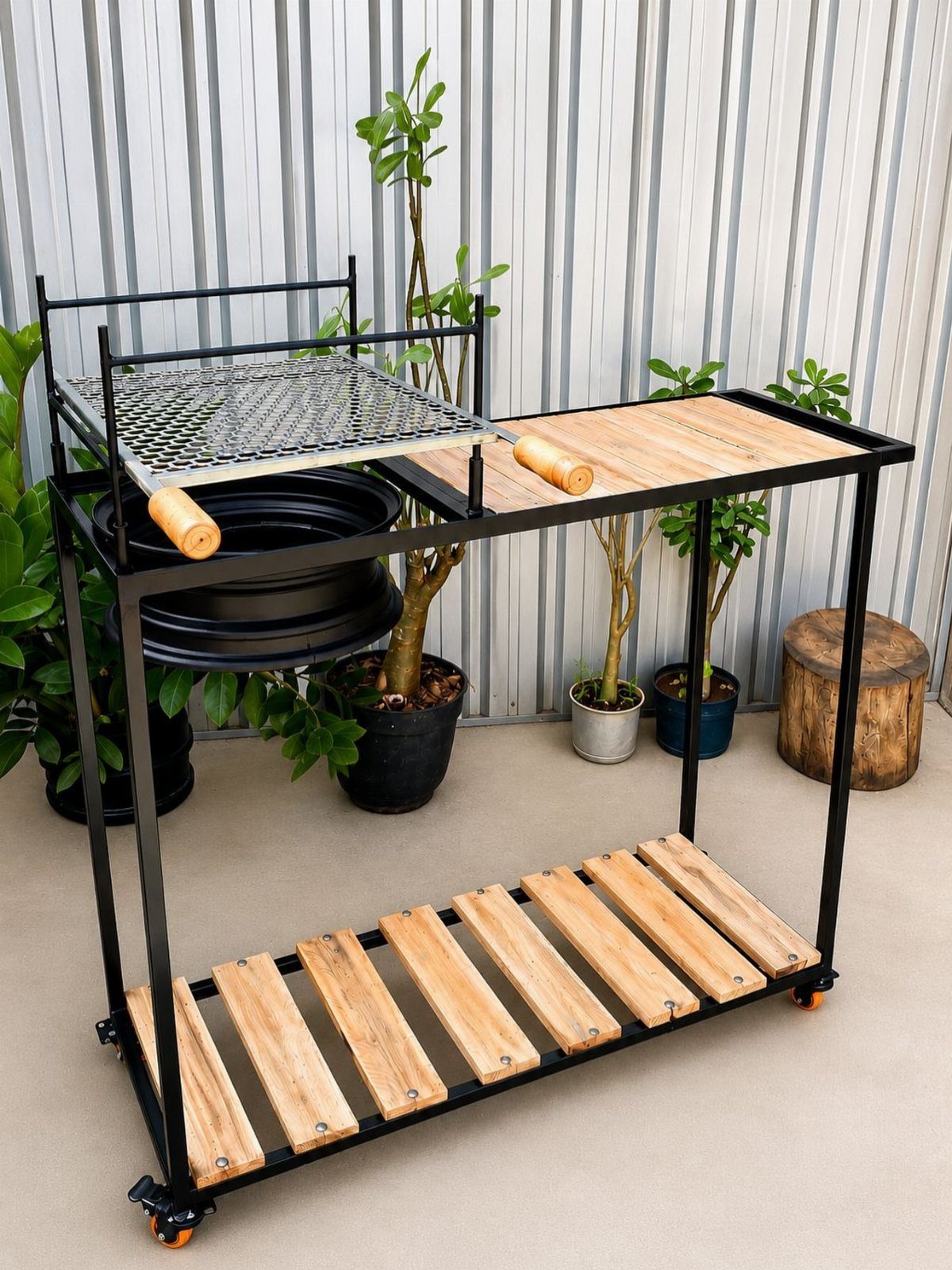 A black metal mobile grill cart with wooden slats and small wheels on a patio.