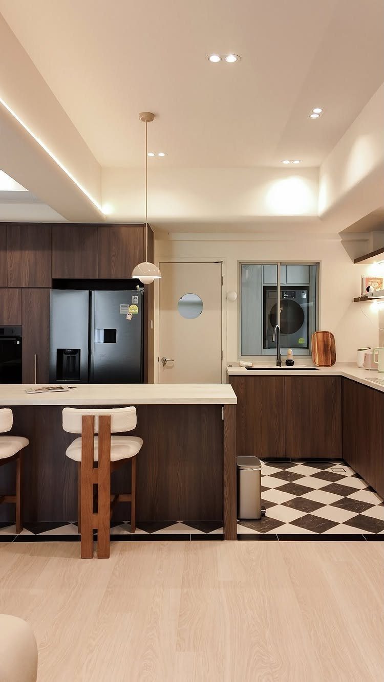 A modern kitchen island with dark wood cabinetry and a white countertop with bar stools.