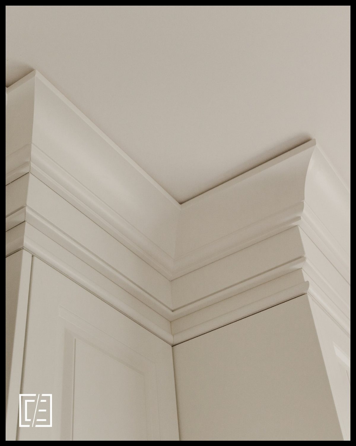 White crown molding installed at the corner where the ceiling meets the top of white cabinets.